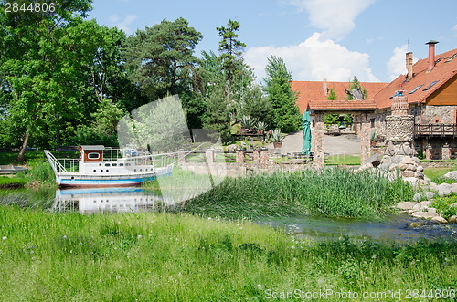 Image of cruise wherry moored at pier near ancient manor  