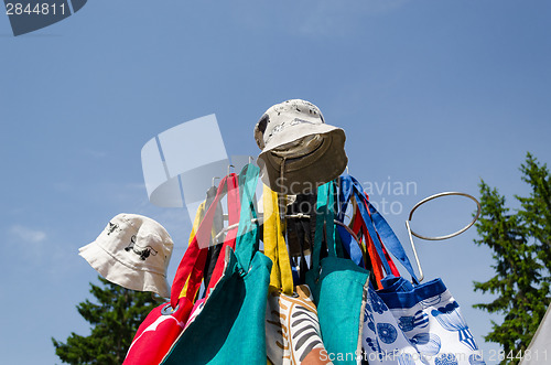 Image of linen cap bag on fair stand on blue sky background