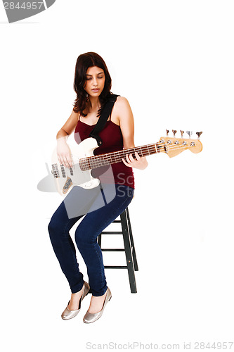 Image of Sitting woman playing guitar.