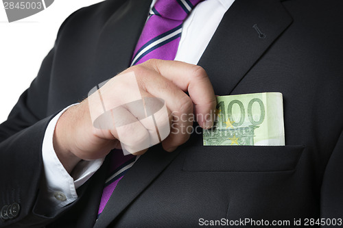 Image of Businessman putting money in pocket