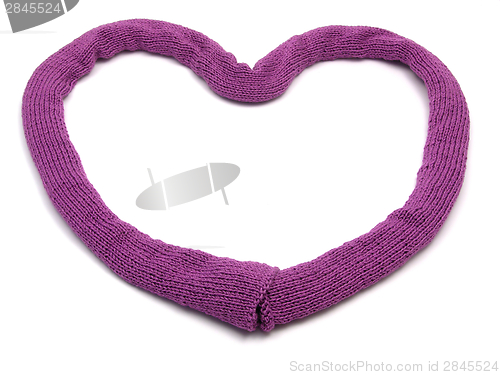 Image of Deep pink knitting scarf arranged as heart on white