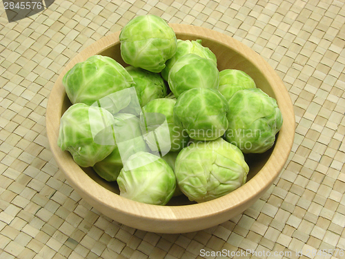 Image of Wooden bowl with brussels sprouts on rattan underlay