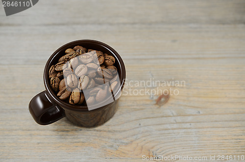 Image of brown cup with coffee beans 