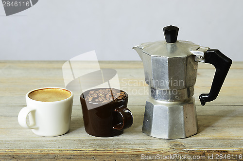 Image of two cups of coffee and beans and percolator