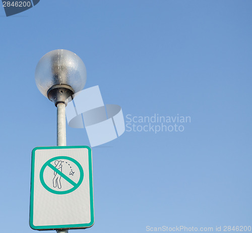 Image of warning sign on littering streets on street lamp 