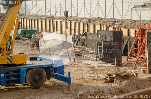 Image of construction site workers machinery scaffolding 