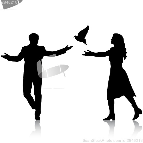 Image of Concept of love or peace. Silhouettes girl and guy released dove