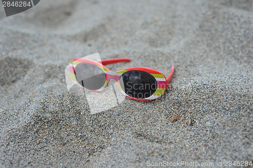 Image of Children's striped sunglasses on the sand