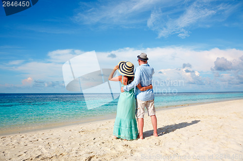 Image of Vacation Couple walking on tropical beach Maldives.