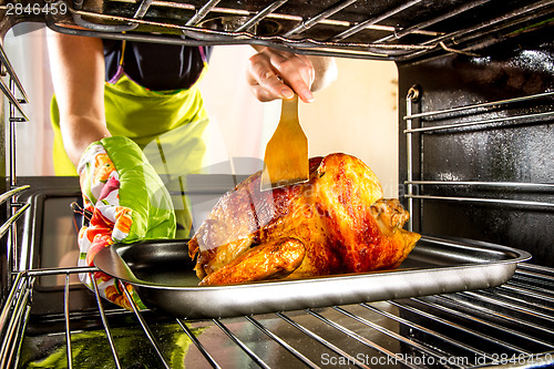 Image of Cooking chicken in the oven at home.