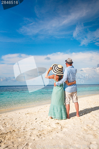 Image of Vacation Couple walking on tropical beach Maldives.