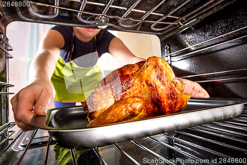 Image of Cooking chicken in the oven at home.