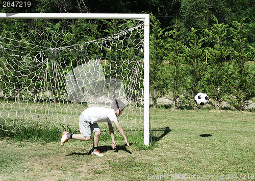 Image of Child playing football in a stadium