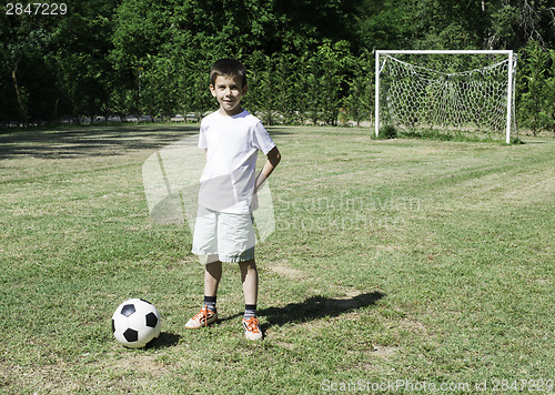 Image of Child playing football in a stadium