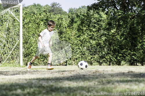 Image of Child playing football in a stadium