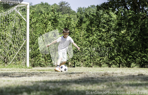 Image of Child playing football in a stadium