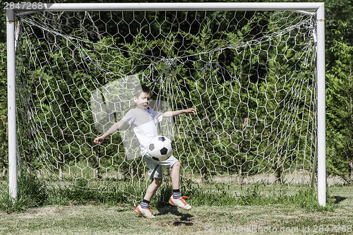 Image of Child playing football in a stadium