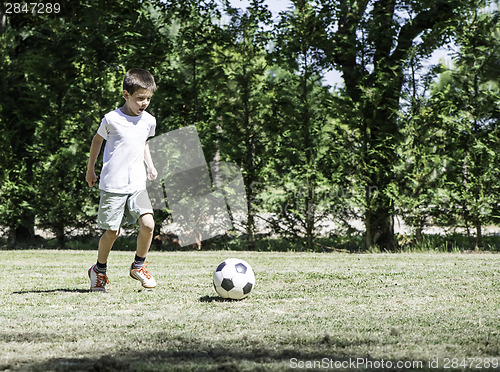 Image of Child playing football in a stadium