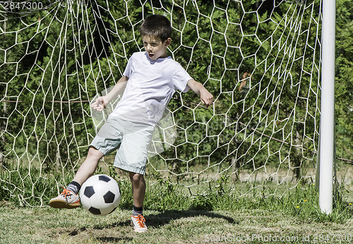Image of Child playing football in a stadium
