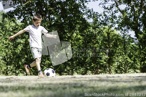 Image of Child playing football in a stadium