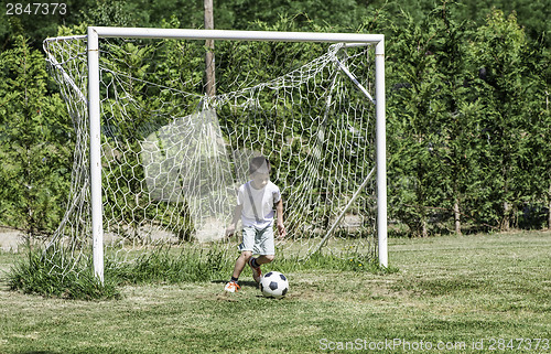 Image of Child playing football in a stadium