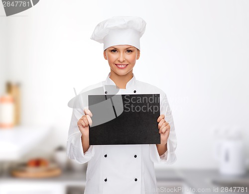 Image of smiling female chef with black blank paper