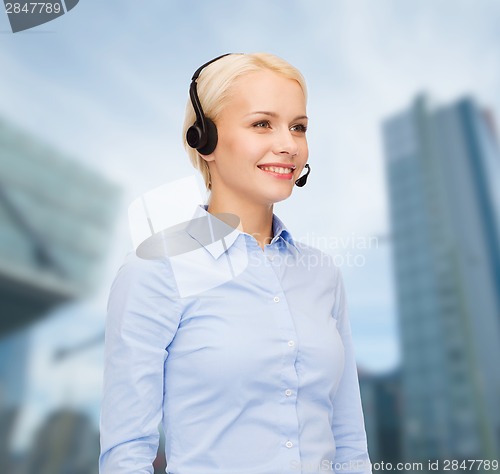 Image of friendly female helpline operator with headphones