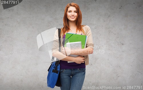 Image of smiling student with bag, folders and tablet pc