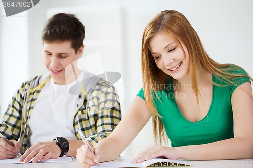 Image of smiling students with textbooks at school