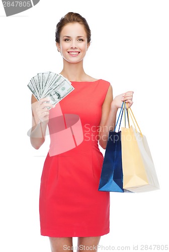 Image of smiling elegant woman in dress with shopping bags