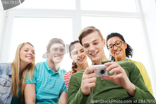 Image of smiling students with digital camera at school