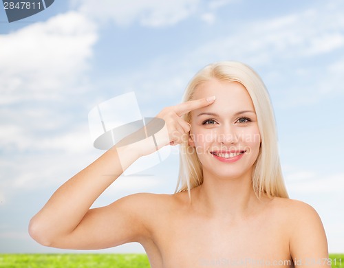 Image of beautiful woman touching her forehead