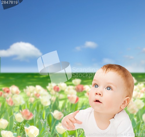 Image of curious baby lying on floor and looking up