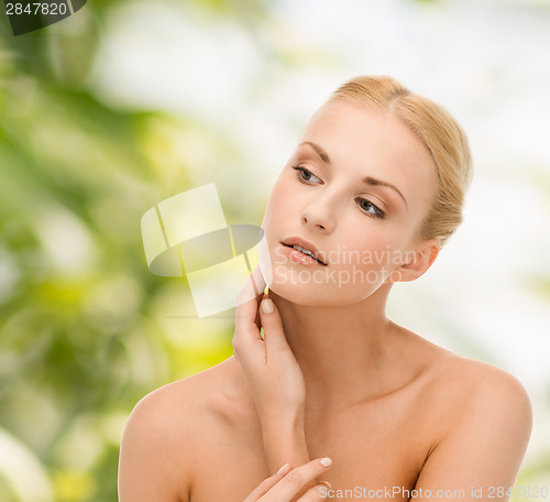Image of beautiful woman touching her face skin