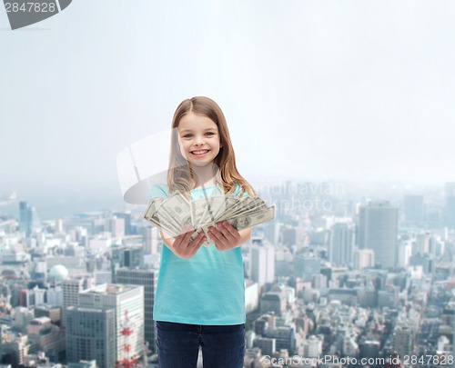 Image of smiling little girl giving dollar cash money