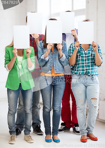 Image of students covering faces with blank papers