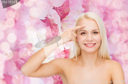 Image of beautiful woman touching her forehead