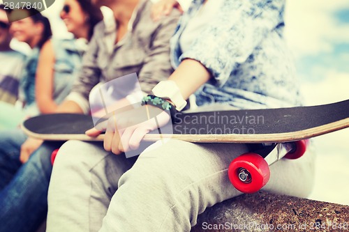 Image of close up of female hand holding skateboard