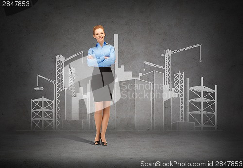 Image of young smiling businesswoman with crossed arms