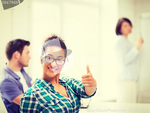 Image of african student girl showing thumbs up