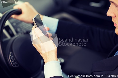 Image of man using phone while driving the car