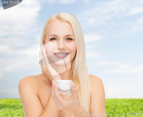 Image of woman applying cream on her skin