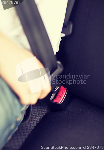 Image of man fastening seat belt in car