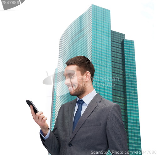 Image of young smiling businessman with smartphone