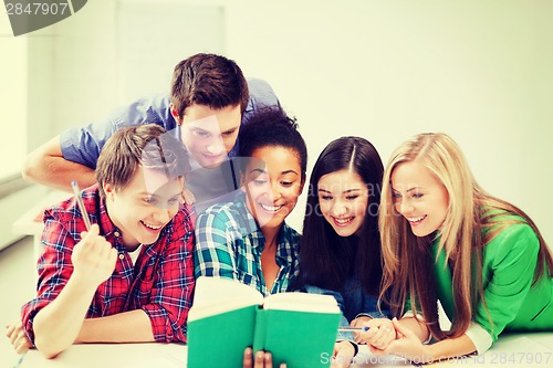 Image of students reading book at school