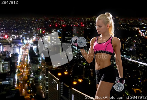 Image of sporty woman with heavy steel dumbbells