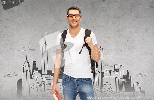 Image of smiling student with backpack and book