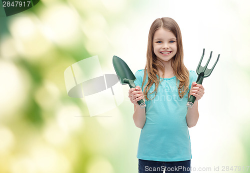 Image of smiling little girl with rake and scoop