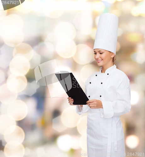 Image of smiling female chef with black blank paper