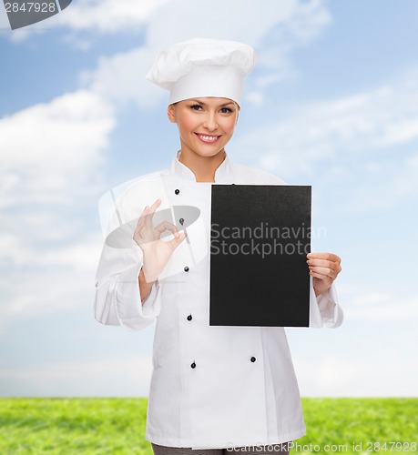 Image of smiling female chef with black blank paper